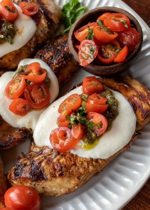 This Chicken Margherita recipe is full of fresh flavors! Balsamic Grilled Chicken is topped with fresh mozzarella, creamy pesto, and a bright tomato basil salad!