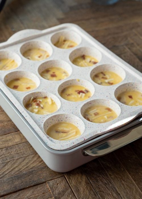 A muffin tray filled with egg bite batter