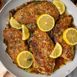 Overhead view of lemon chicken in skillet with lemon slices