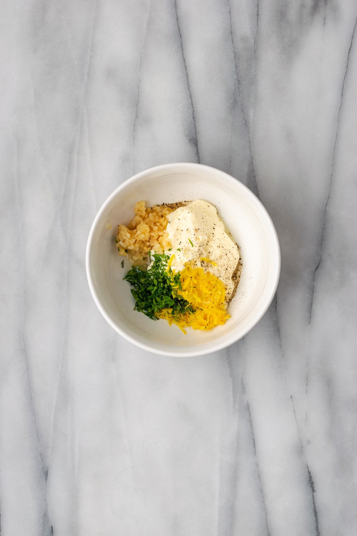 Overhead view of ingredients for aioli in bowl