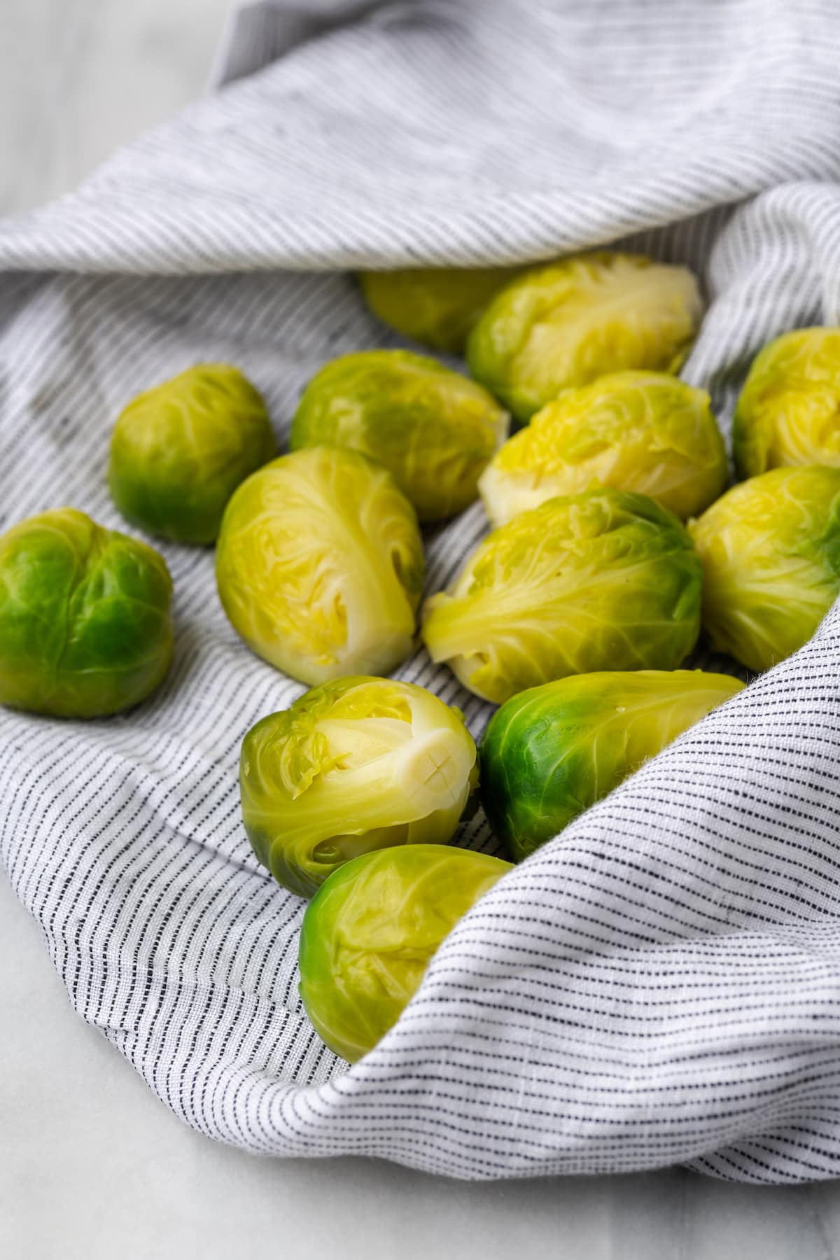 Boiled Brussels sprouts being dried with kitchen towel