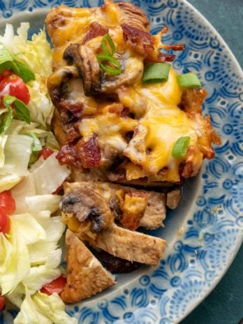 Cheesy chicken and a salad on blue plate