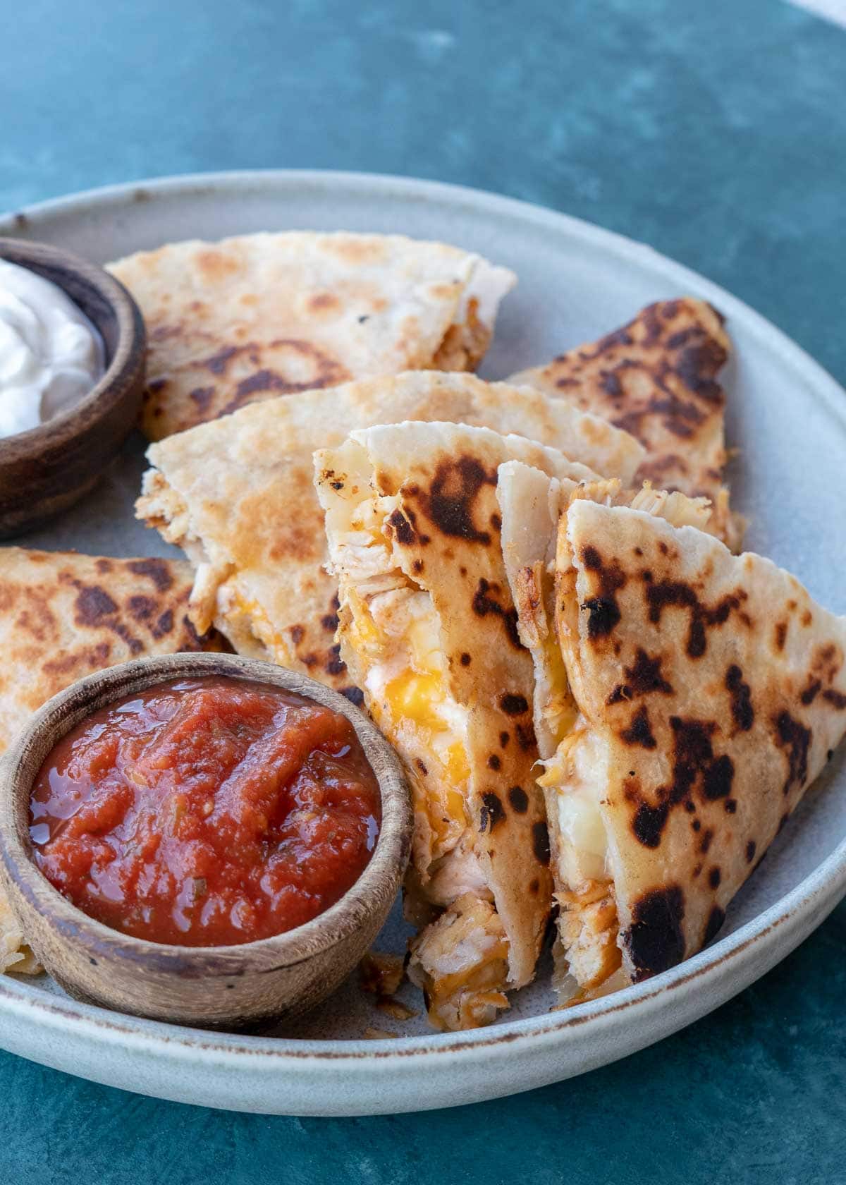 Learn how to make the best Chicken Quesadilla! This easy chicken recipe features a crispy tortilla loaded with two kinds of cheese, tender chicken, and a savory sauce. 