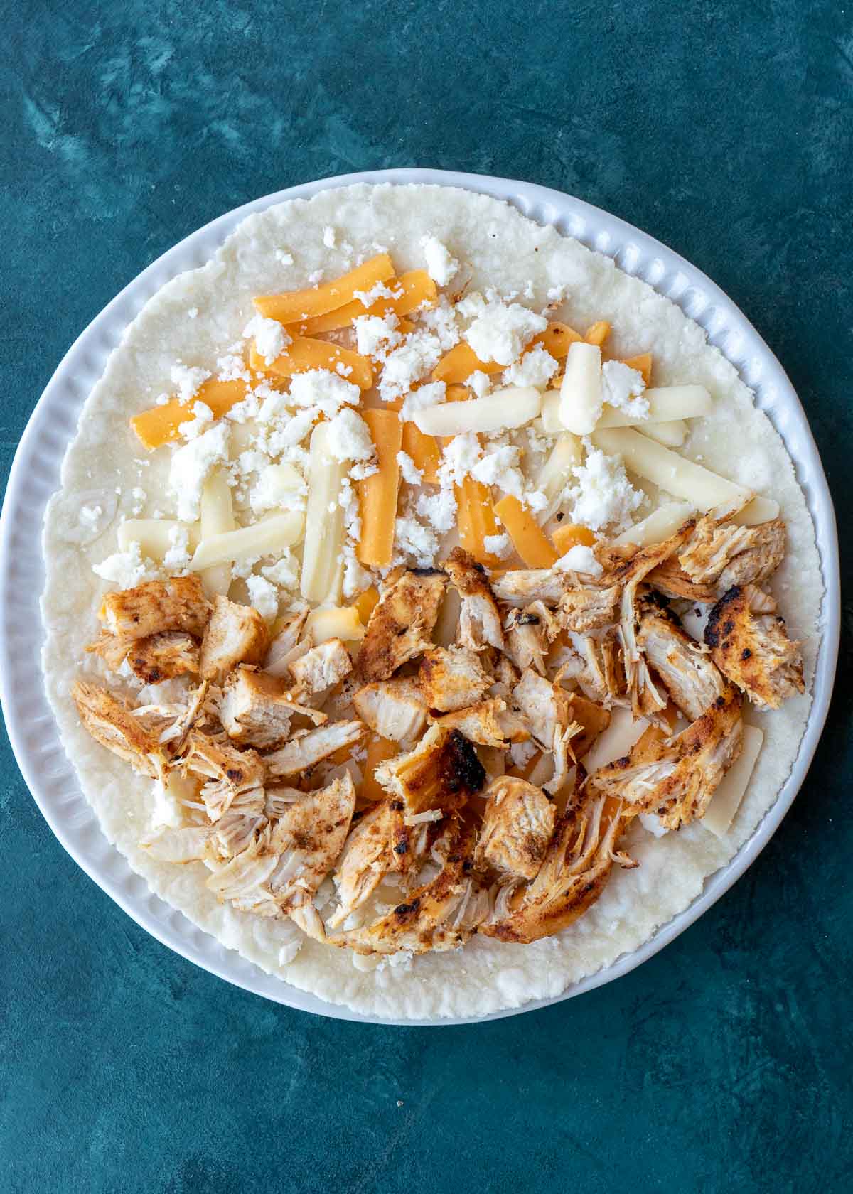 Learn how to make the best Chicken Quesadilla! This easy chicken recipe features a crispy tortilla loaded with two kinds of cheese, tender chicken, and a savory sauce. 