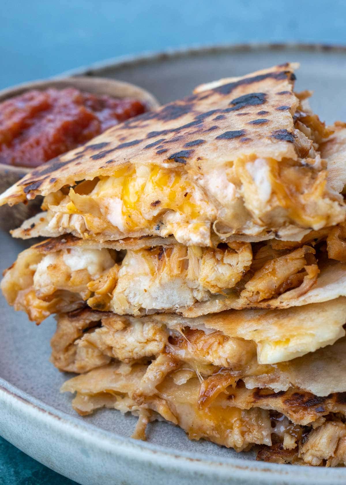 Learn how to make the best Chicken Quesadilla! This easy chicken recipe features a crispy tortilla loaded with two kinds of cheese, tender chicken, and a savory sauce. 