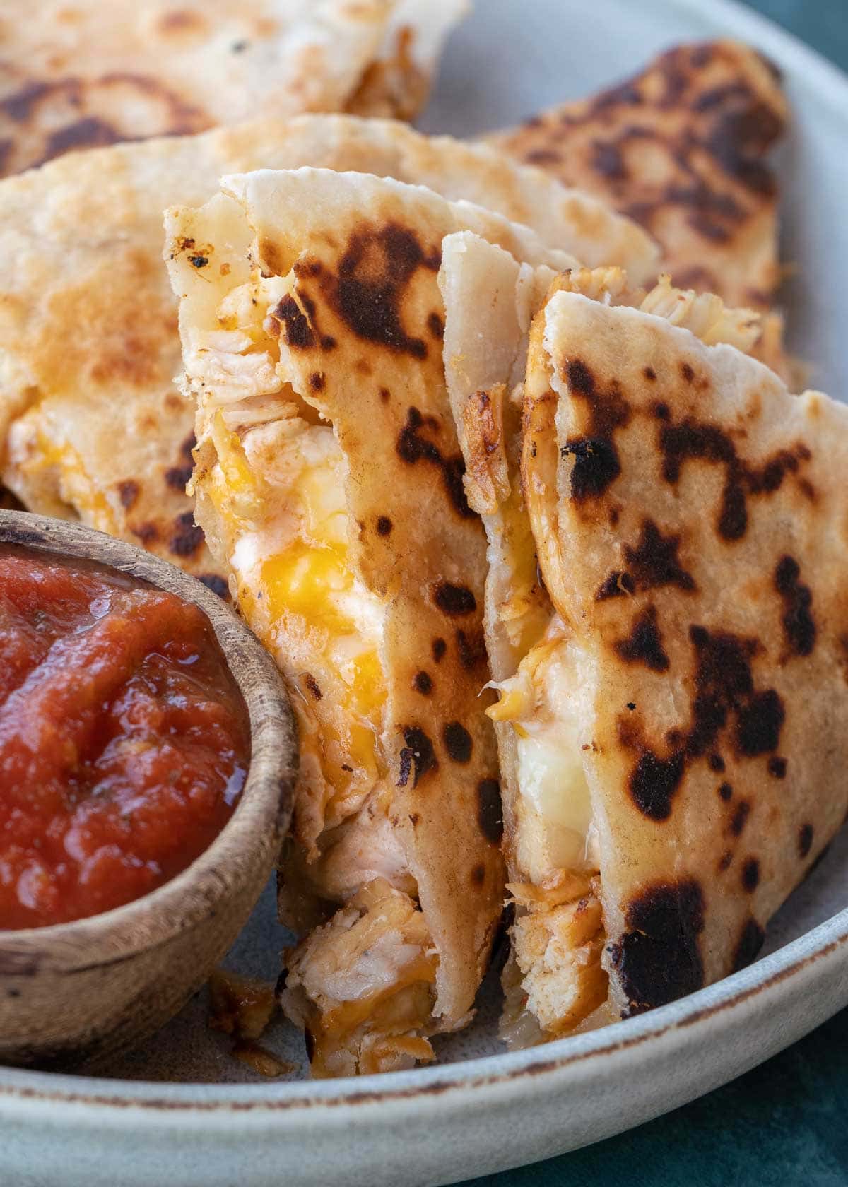 Learn how to make the best Chicken Quesadilla! This easy chicken recipe features a crispy tortilla loaded with two kinds of cheese, tender chicken, and a savory sauce. 