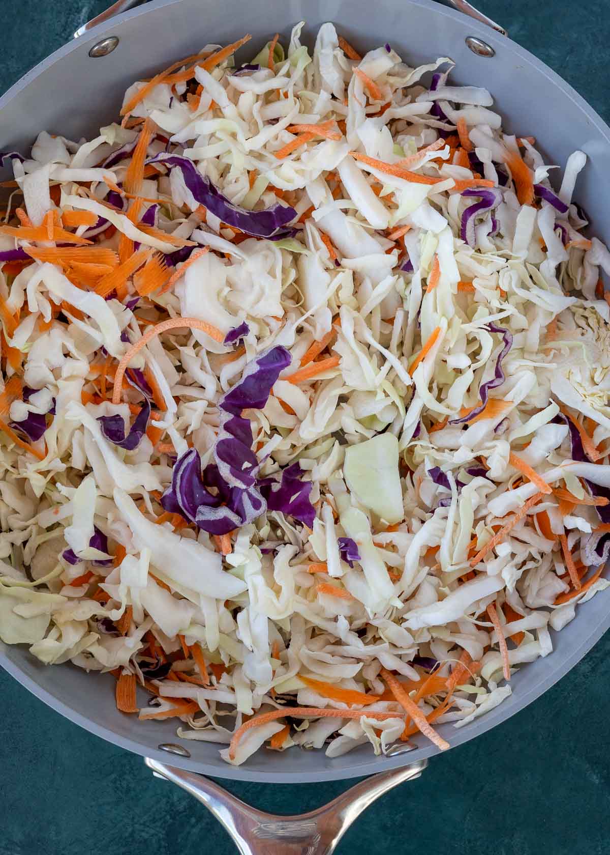 A frying pan filled with cabbage and carrots