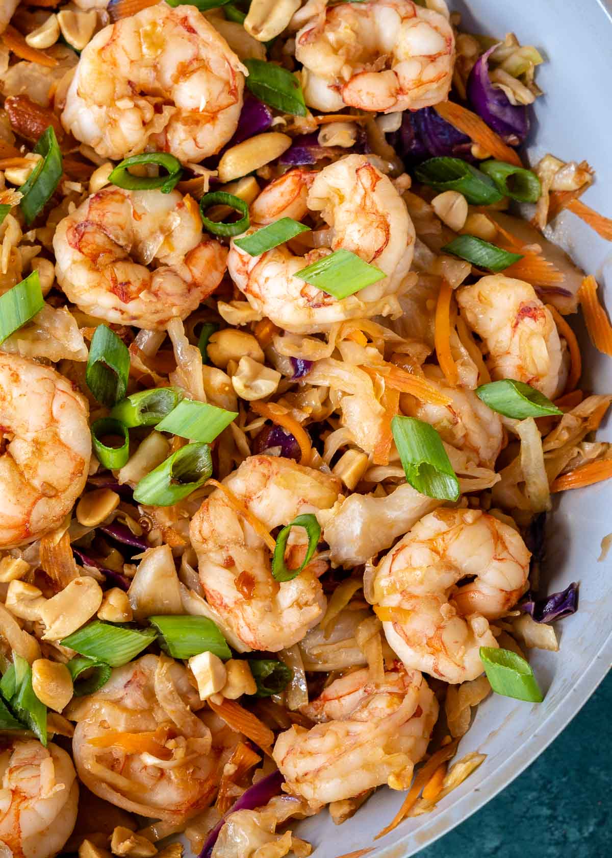 A pan of shrimp stir fry topped with scallions