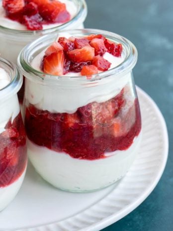 small jar with cheesecake and strawberry layers.