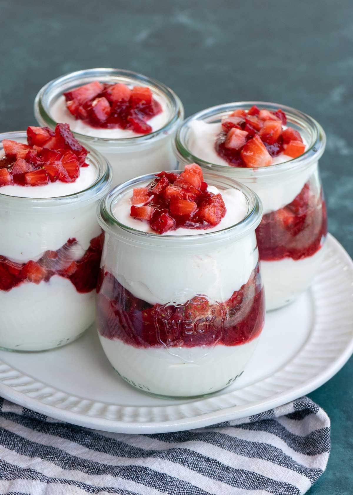 These cute Strawberry Cheesecake Jars are a decadent no-bake dessert! Sweet and creamy vanilla cheesecake is layered with homemade strawberry sauce and fresh berries for the perfect treat!