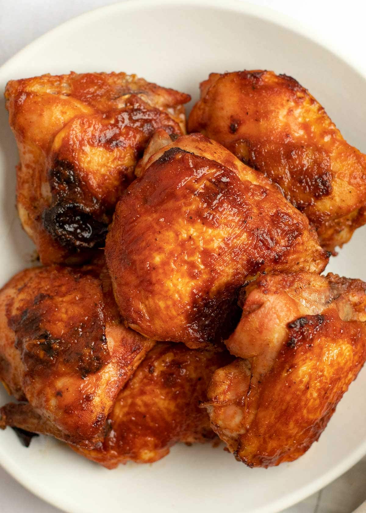 baked bbq chicken thighs on a white plate