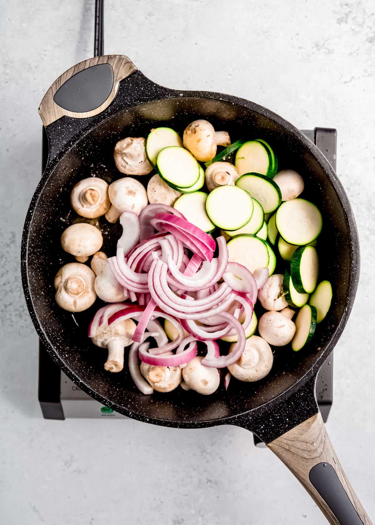 mushrooms, zucchini, and red onion in cast iron skillet