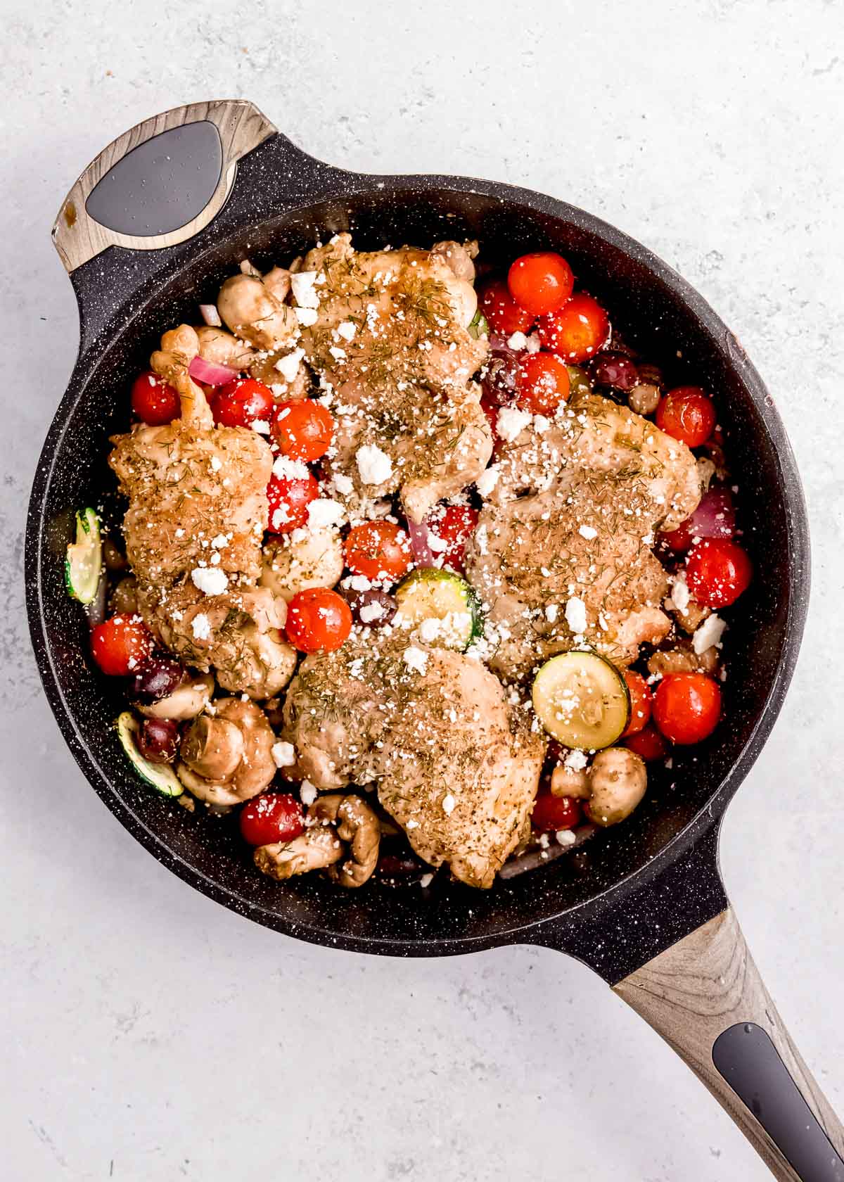 overhead shot of feta sprinkled over cooked one pan chicken and veggies