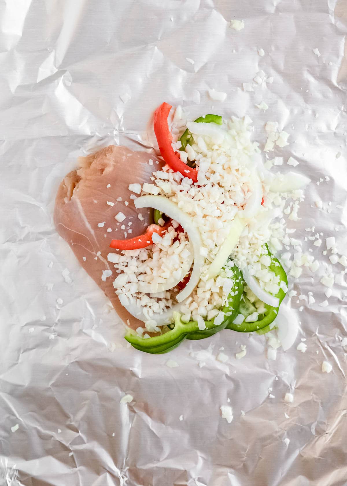 place chicken, peppers, onion, and cauliflower rice in the center of the foil