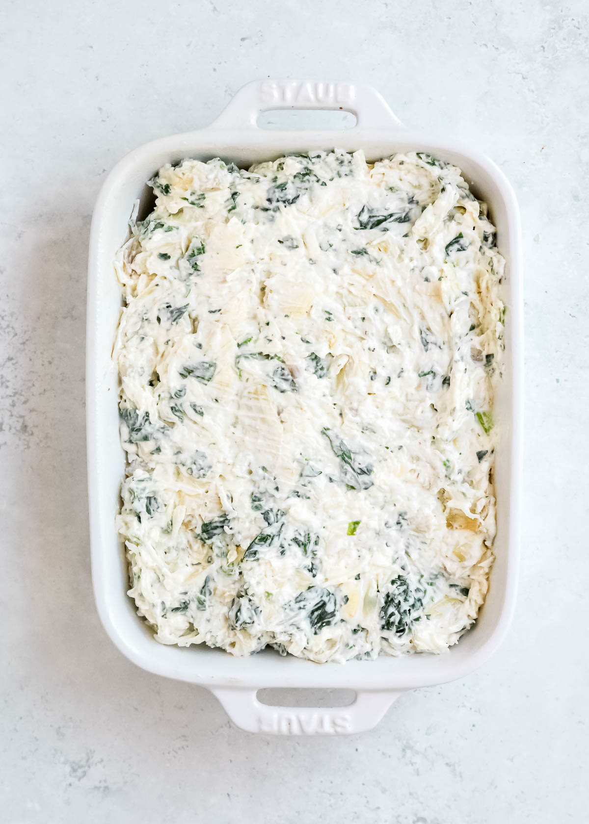 spinach dip spread in a white baking dish