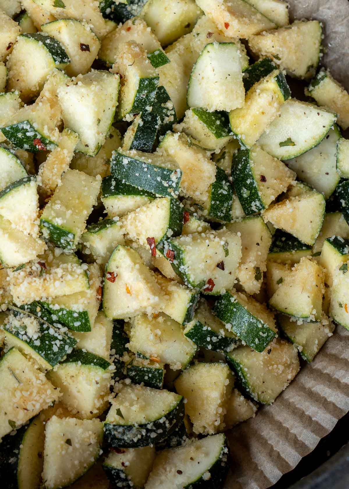 zucchini with parmesan uncooked in an air fryer basket