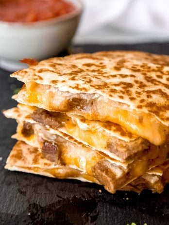 sliced steak quesadilla on a gray background