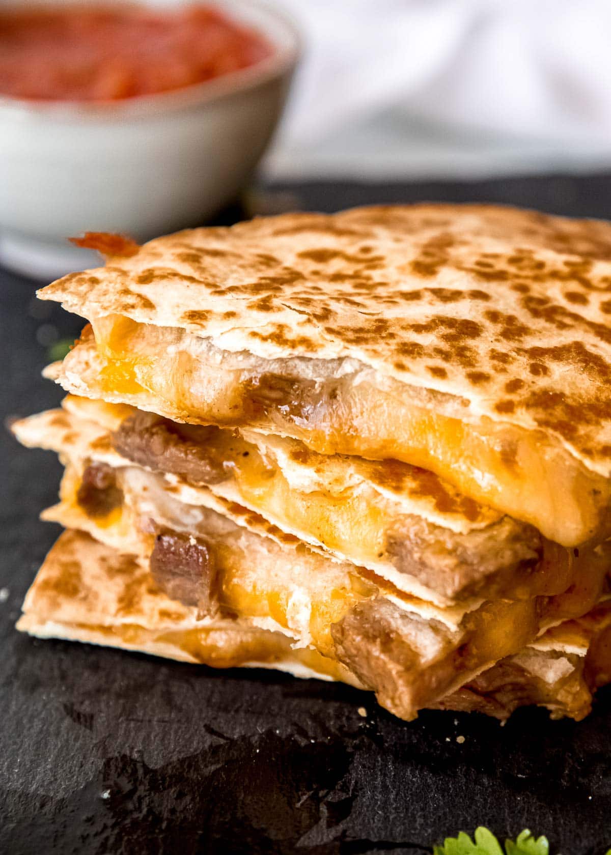 sliced steak quesadilla on a gray background