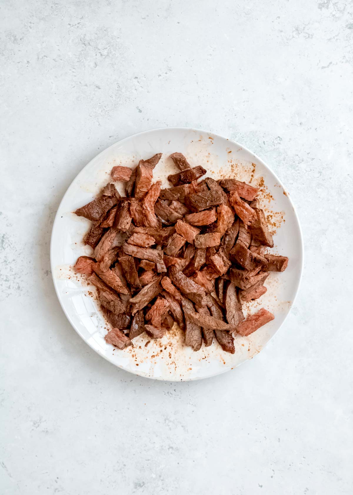 sliced, cooked steak on white plate