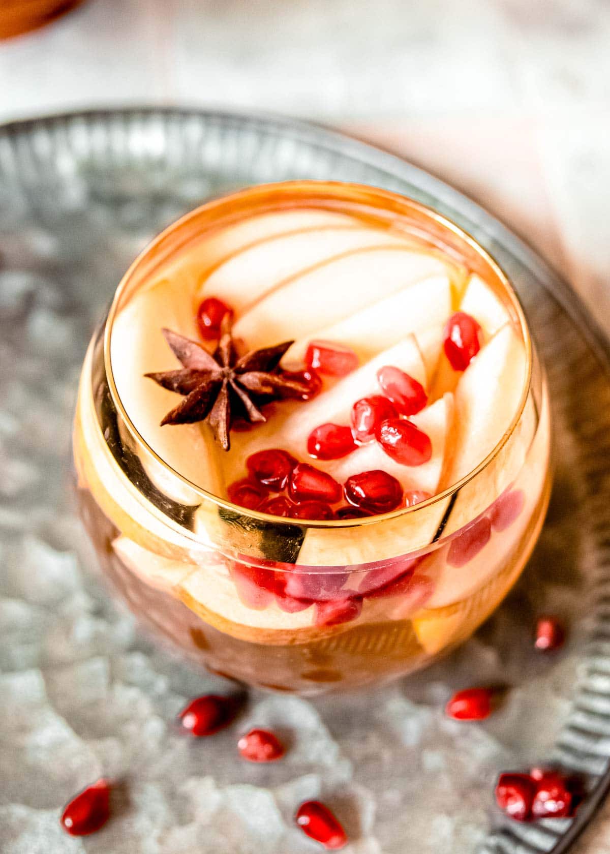 glass of apple sangria with pomegranate seeds