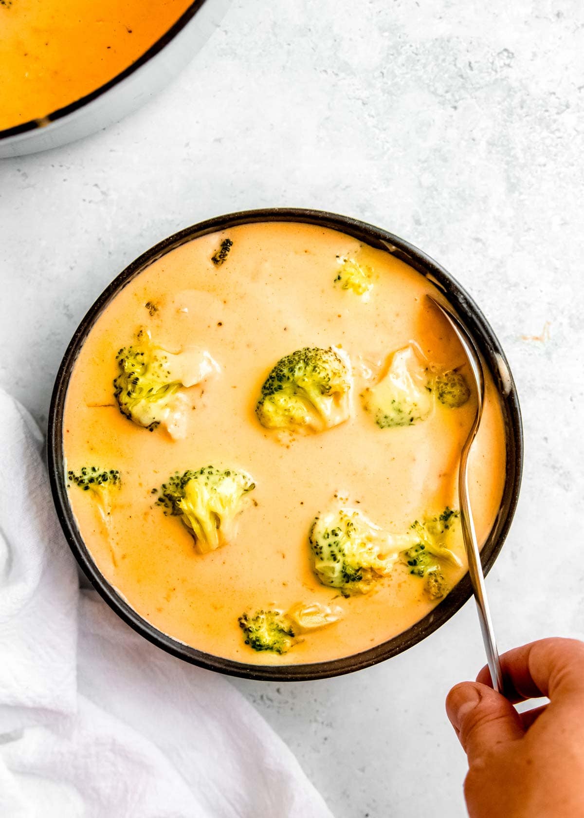 bowl of broccoli cheddar soup with spoon