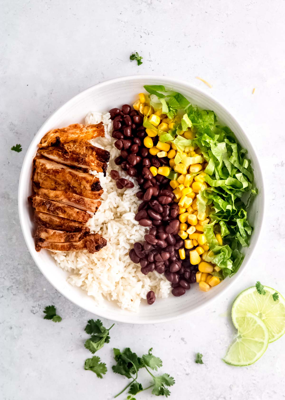 chicken burrito bowl ingredients on a white plate