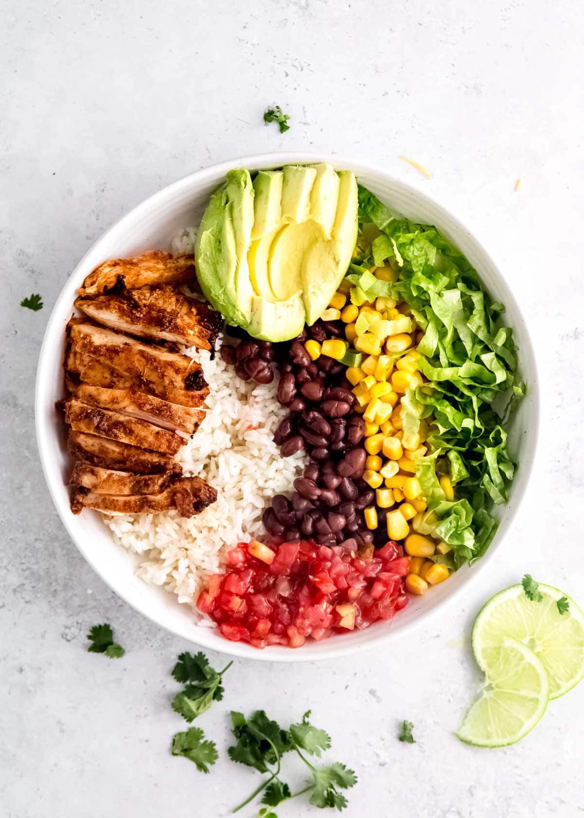 chicken burrito bowl ingredients on a white plate