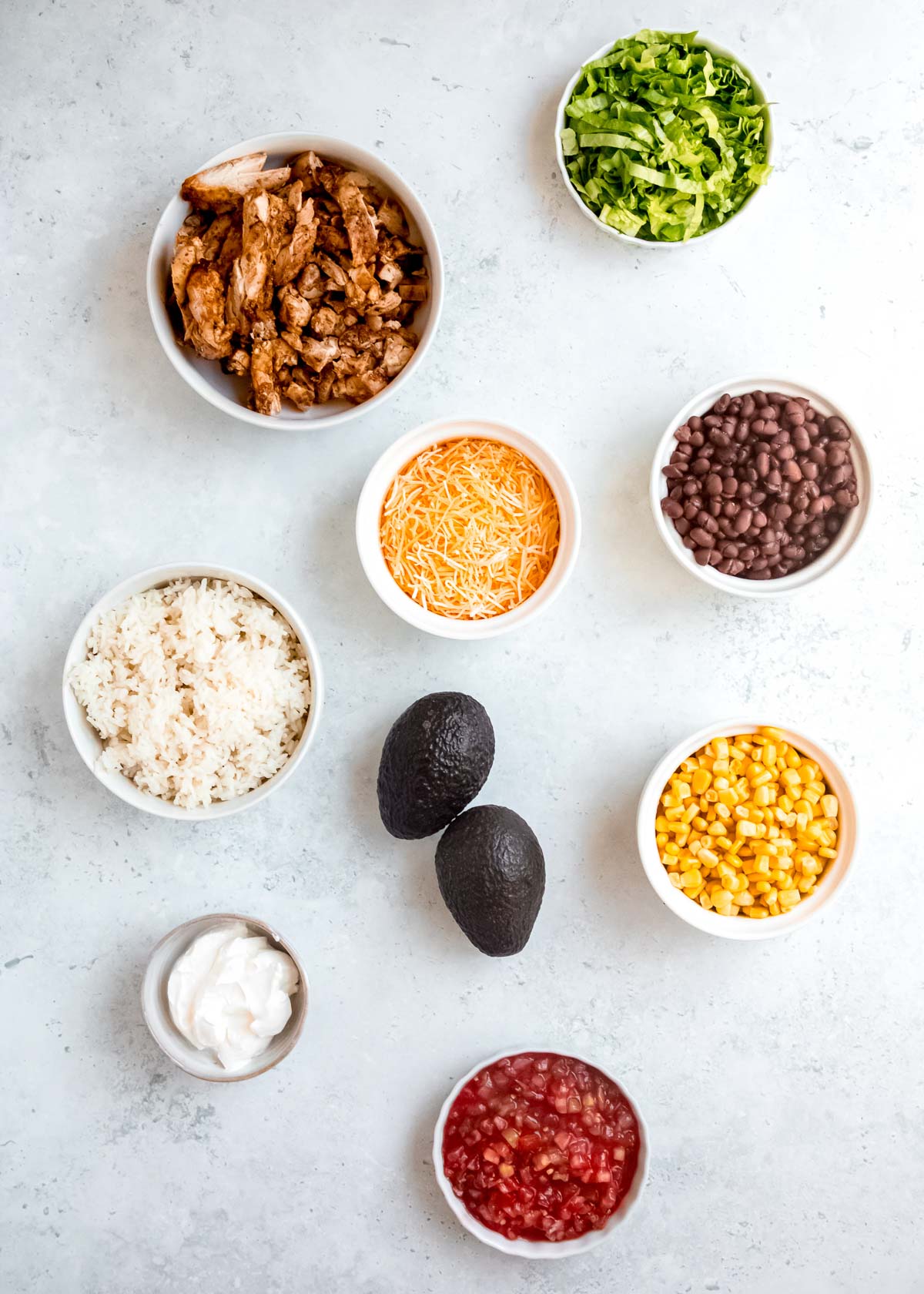 chicken burrito bowl ingredients on a white table