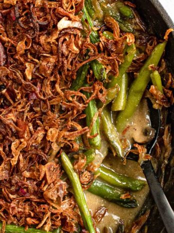 a close up overhead shot of green bean casserole with crispy onions