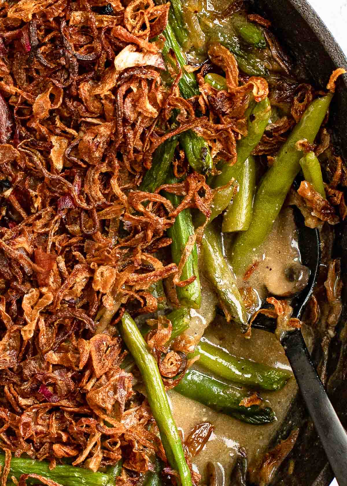 a close up overhead shot of green bean casserole with crispy onions