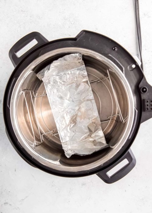 an aluminum foil sling on top of a trivet in the instant pot