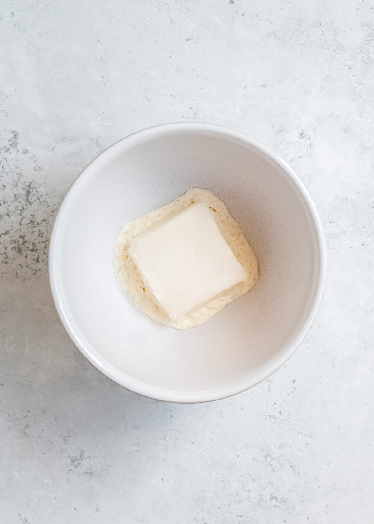 melted cream cheese in a white bowl