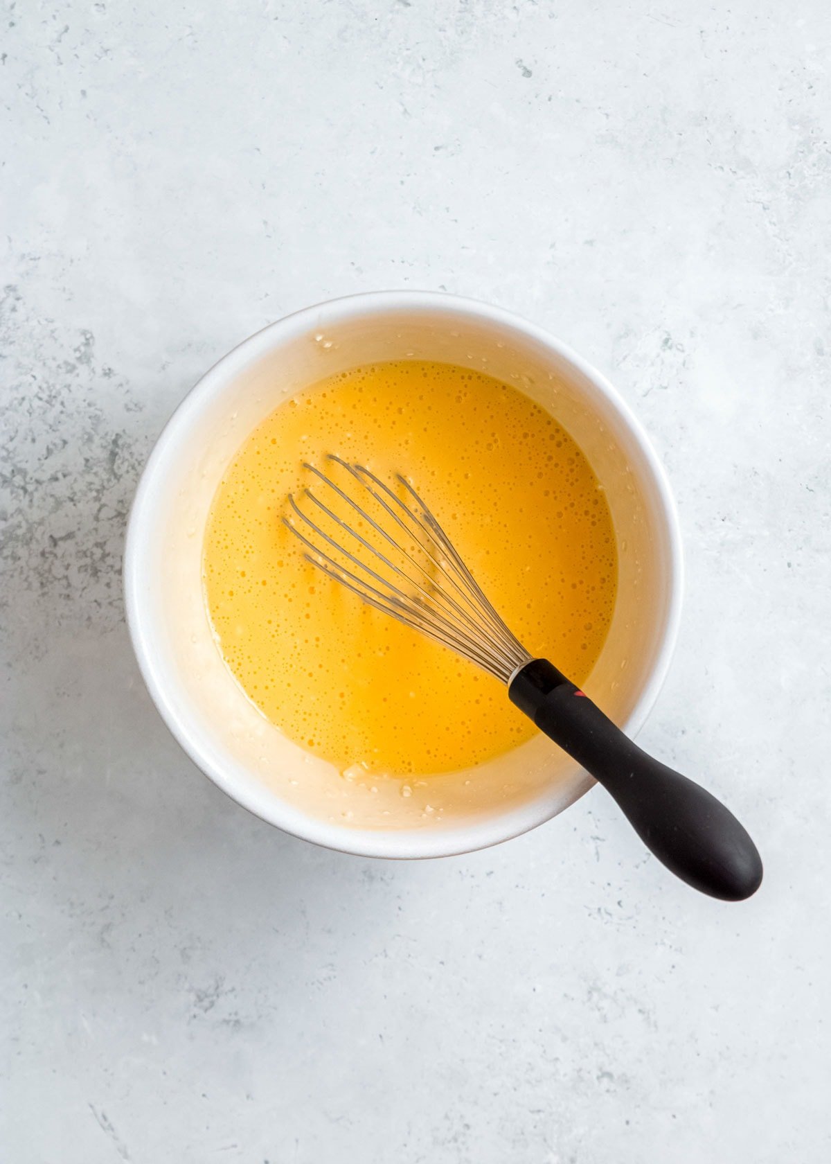 whisked eggs, cream cheese, and shredded cheese in a white bowl