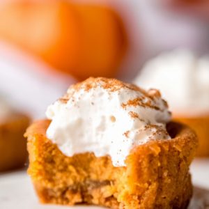 mini pumpkin cheesecake with a bite missing on white plate