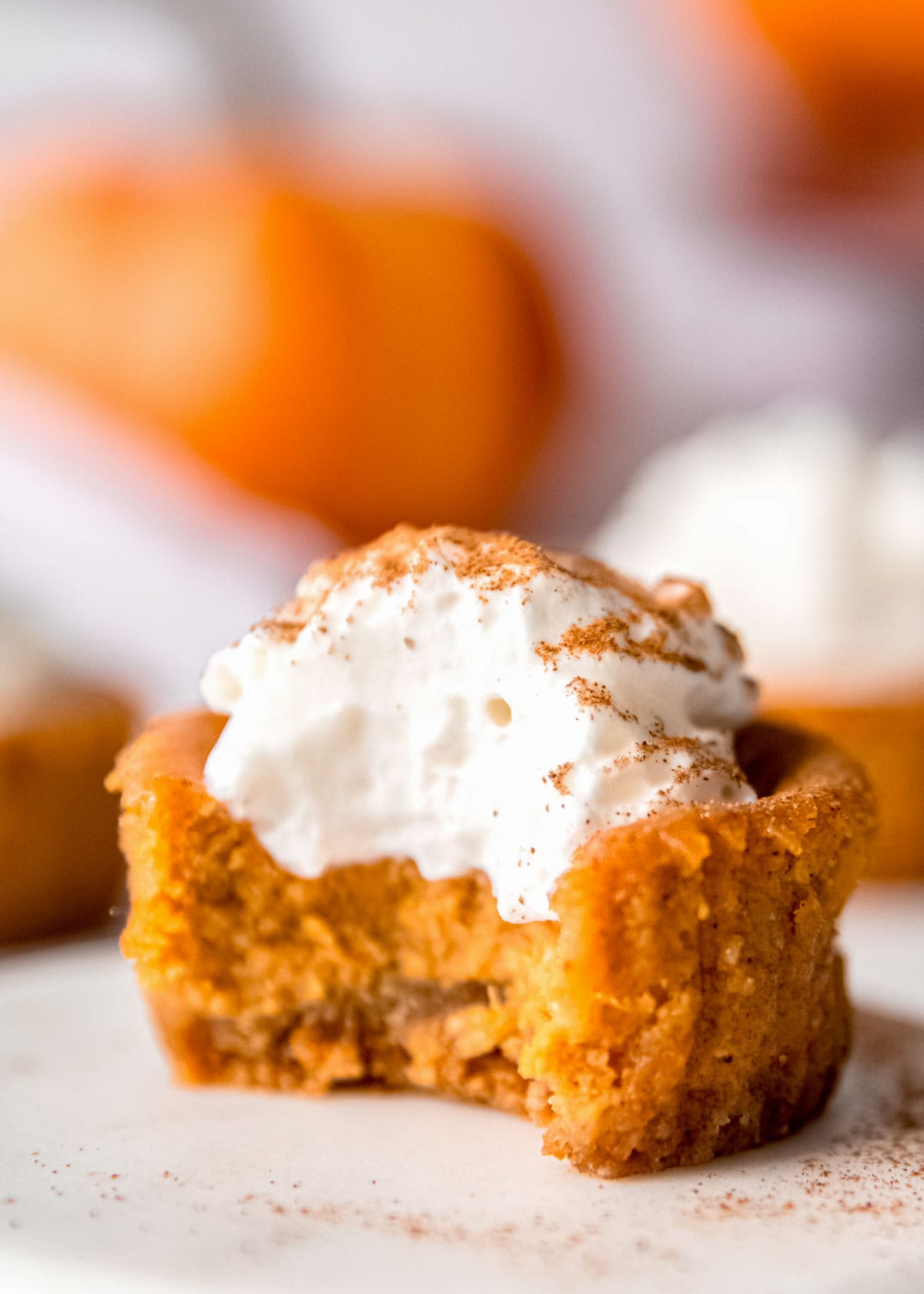 mini pumpkin cheesecake with a bite missing on white plate