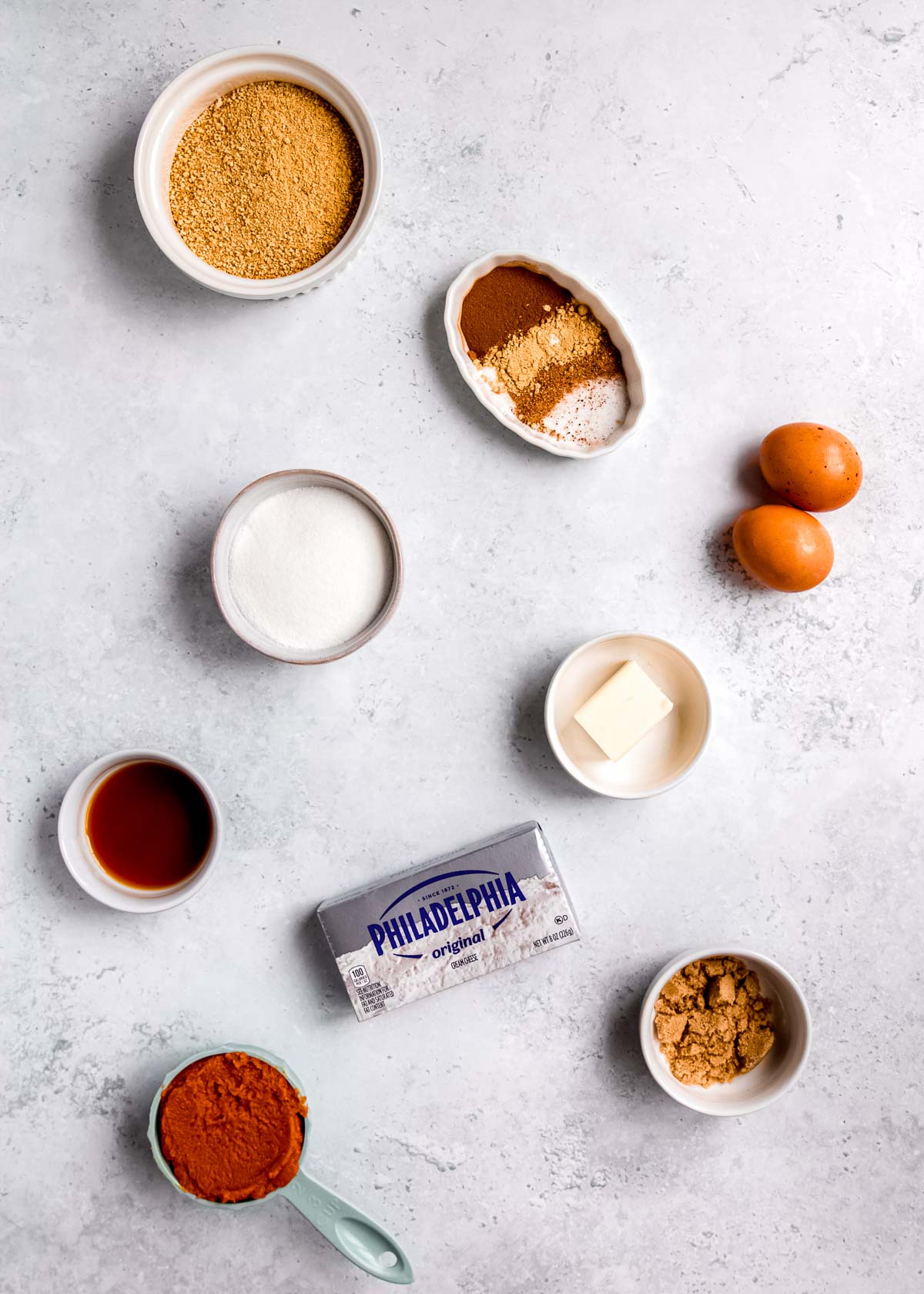 mini pumpkin cheesecake ingredients on a gray countertop