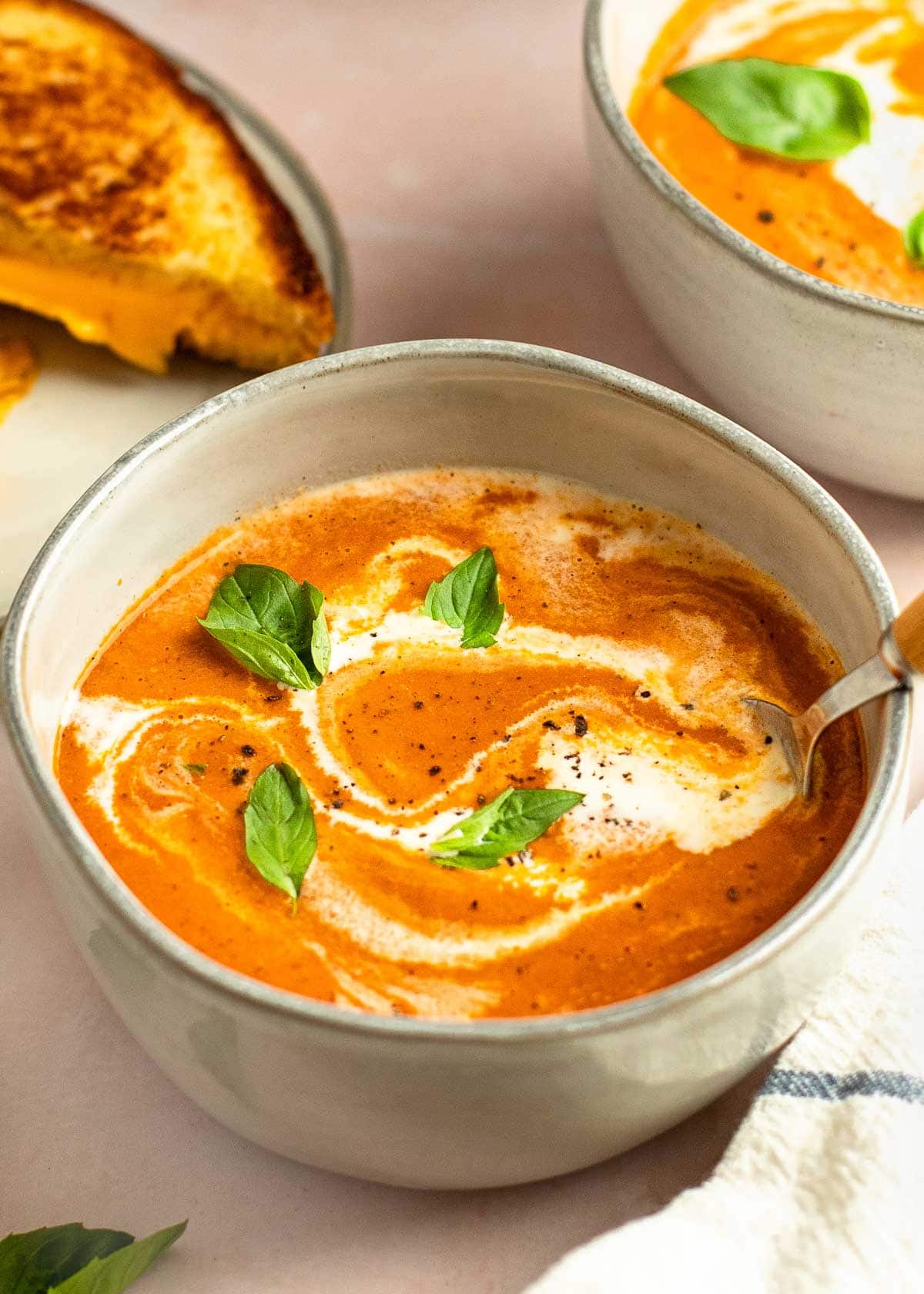 tomato soup in bowl with cream and basil