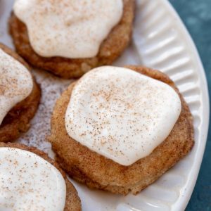 a white plate with frosted snickerdoodle cookies