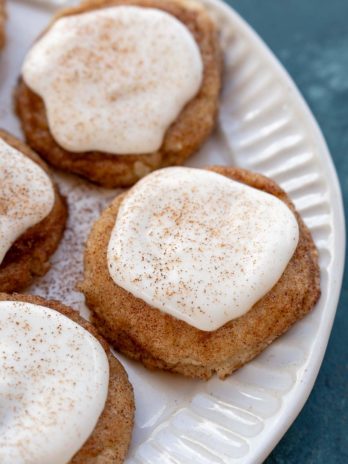 a white plate with frosted snickerdoodle cookies