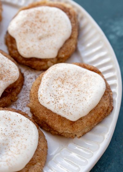 a white plate with frosted snickerdoodle cookies