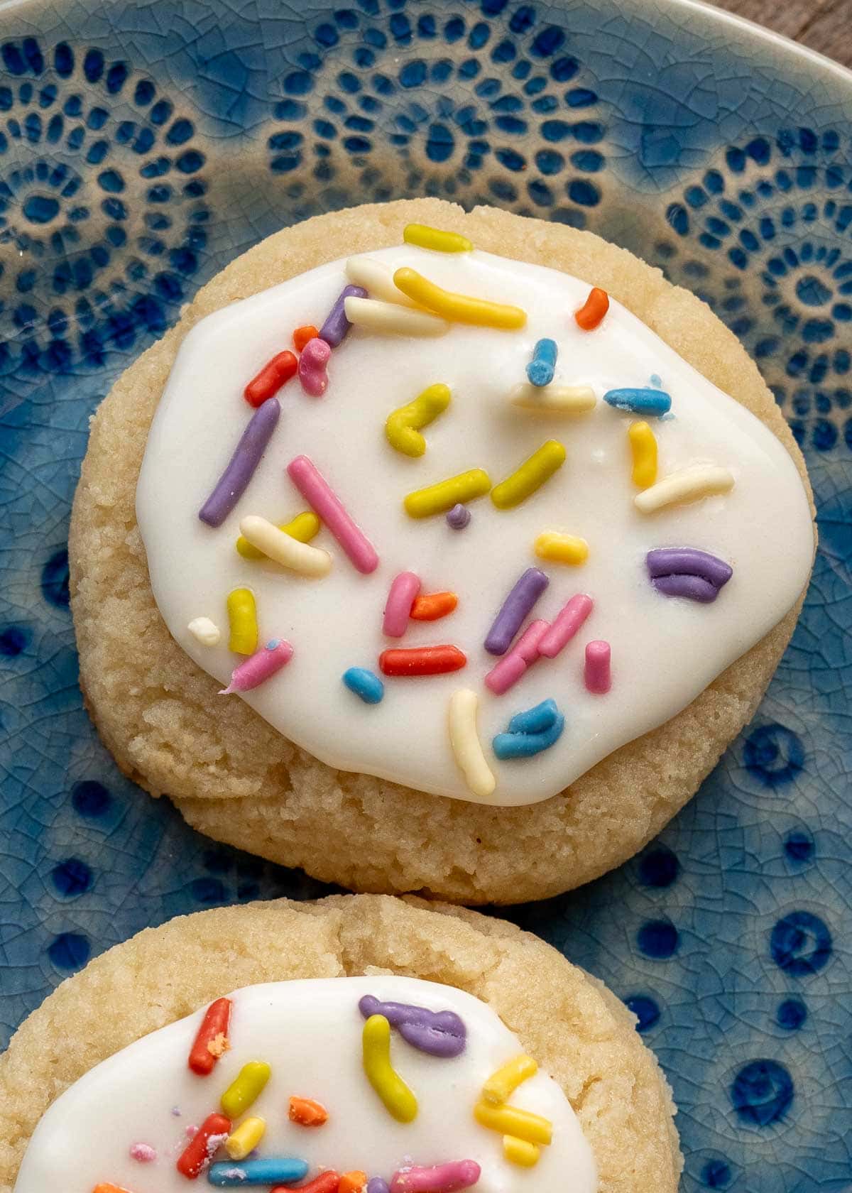closeup shot of iced, sprinkled keto sugar cookie on a plate