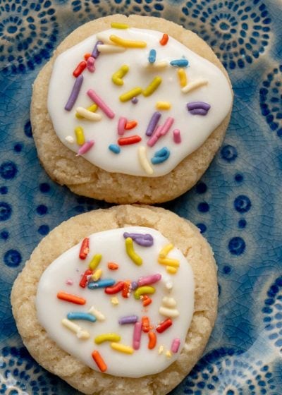 two iced keto sugar cookies on a blue plate
