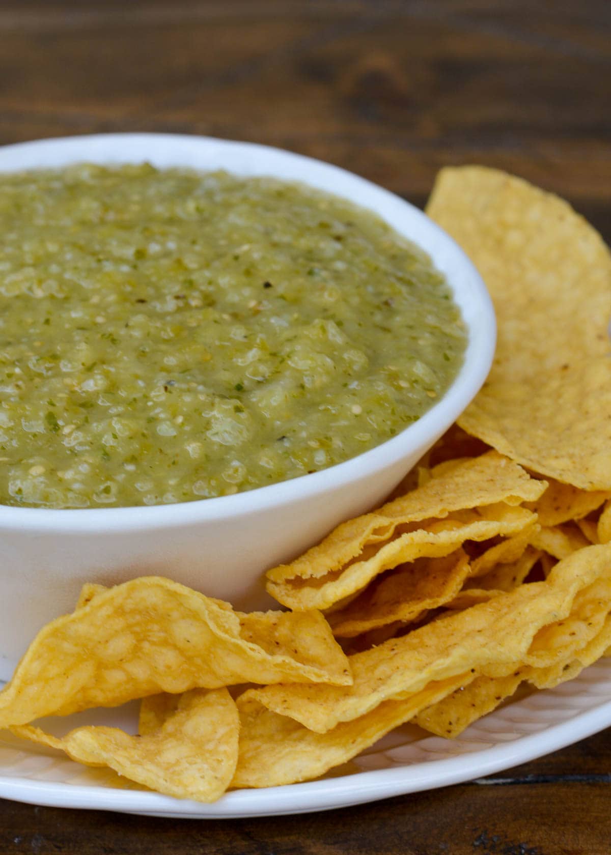 tomatillo salsa in a bowl with a side of tortilla chips