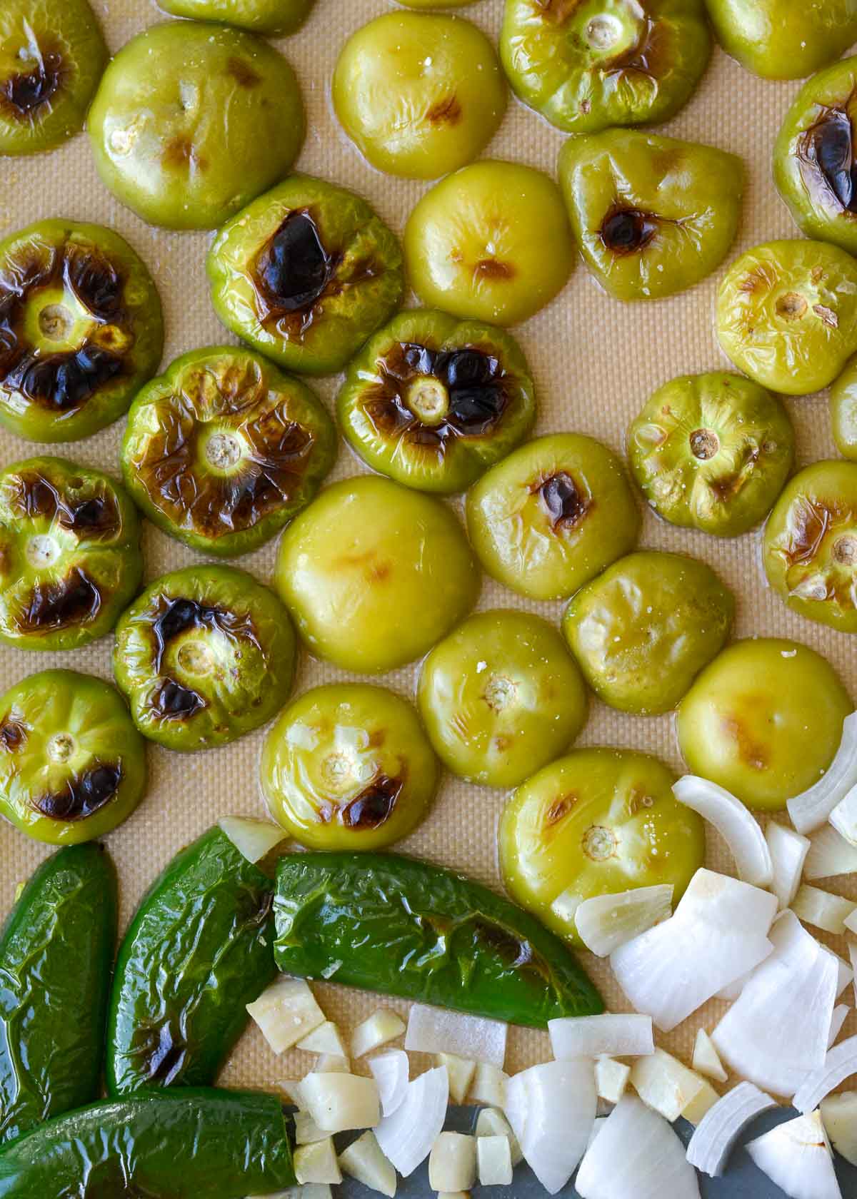 roasted tomatillos, jalapeno, and onion on a sheet pan