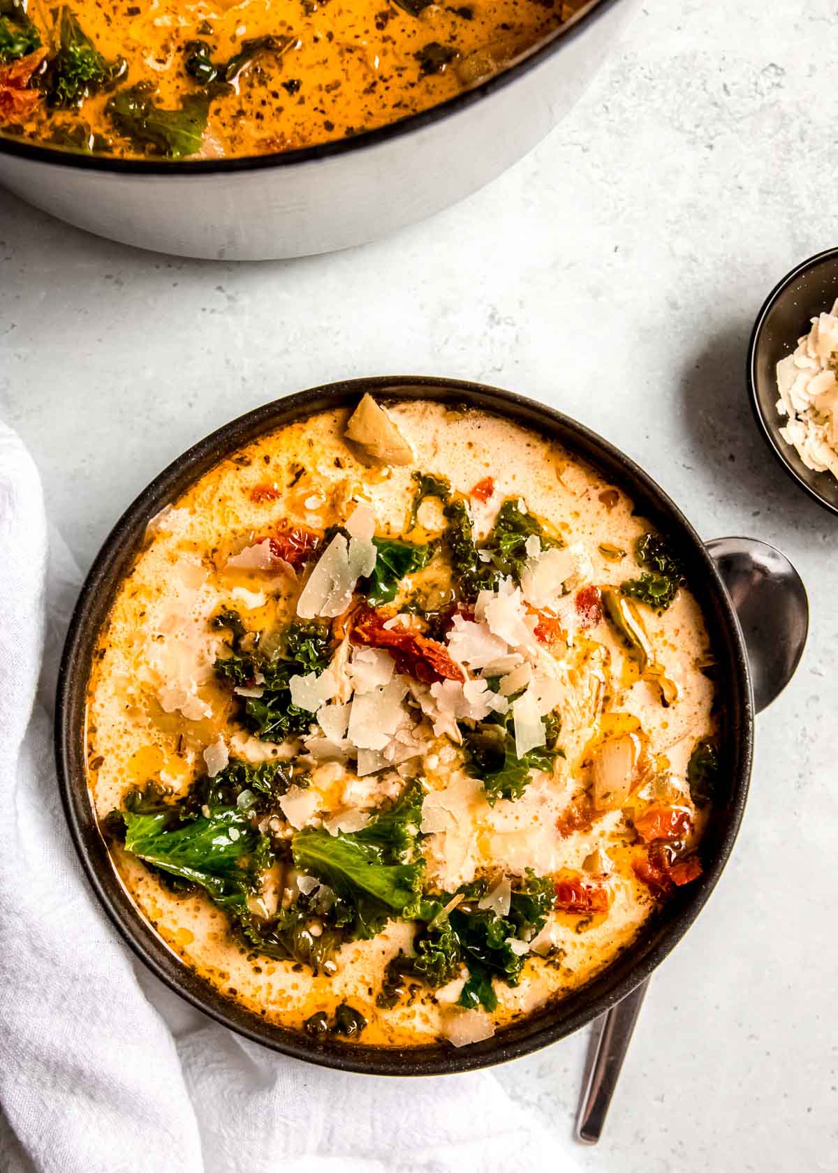 tuscan chicken in a black bowl on a white table