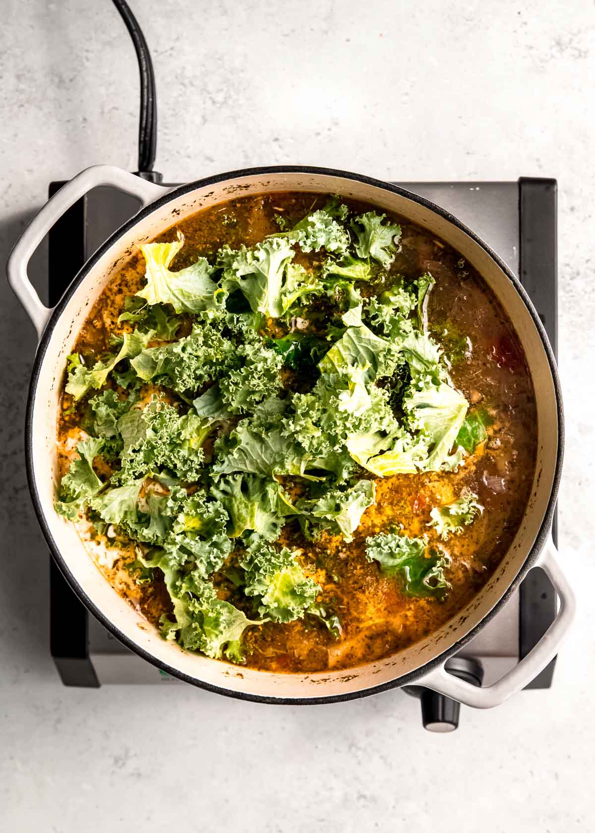 kale being added to dutch oven