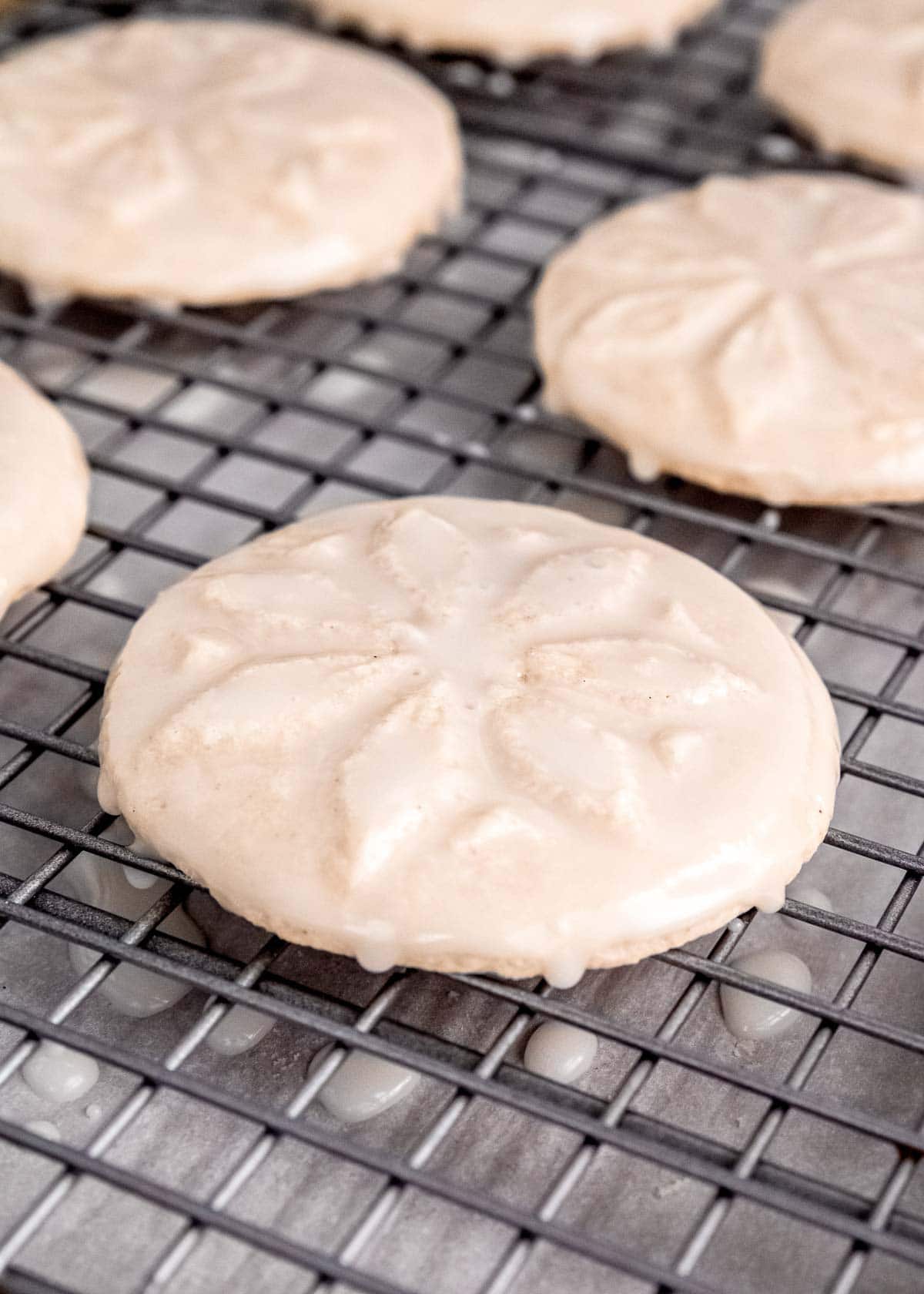 glaze dripping off a gluten-free sugar cookie on a baking rack