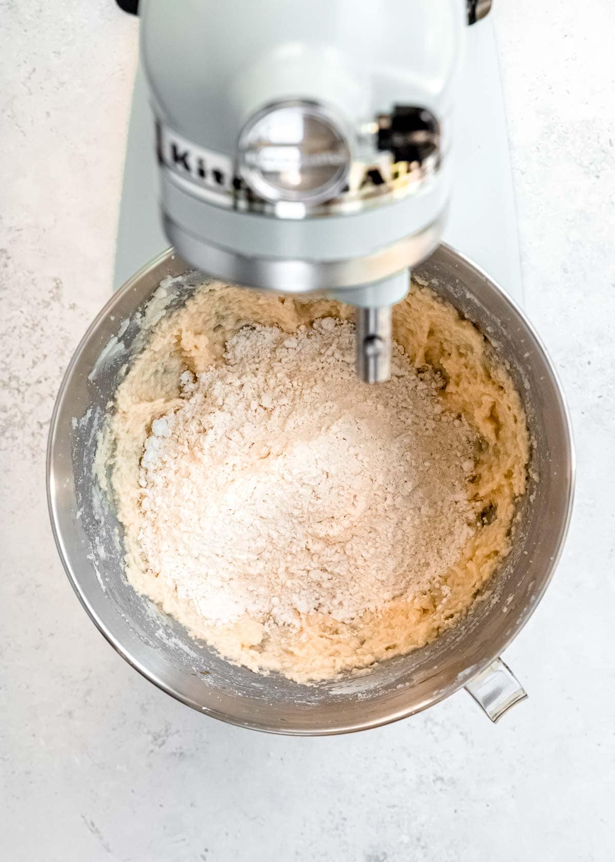 flour and salt added into creamed sugar, egg, and vanilla to make cookie dough