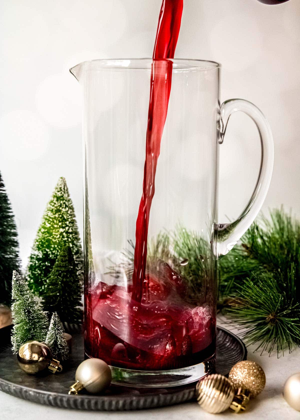 pomegranate juice being poured into a pitcher