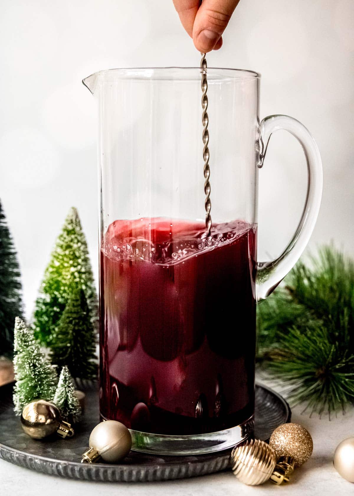 fruit being stirred into cranberry and pomegranate juices for punch